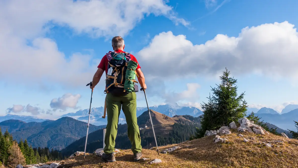 A hiker with a backpack standing on a mountain top