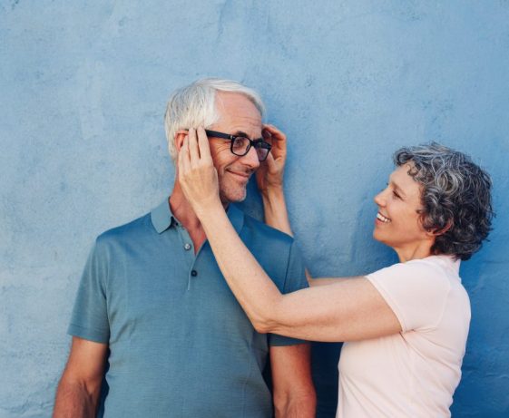 Woman adjusting the eyeglasses on her husband